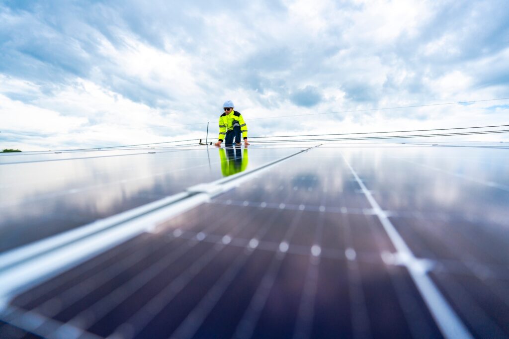 Technicus past een zonnepaneel op het dak aan, om de overgang naar duurzame energie te benadrukken.